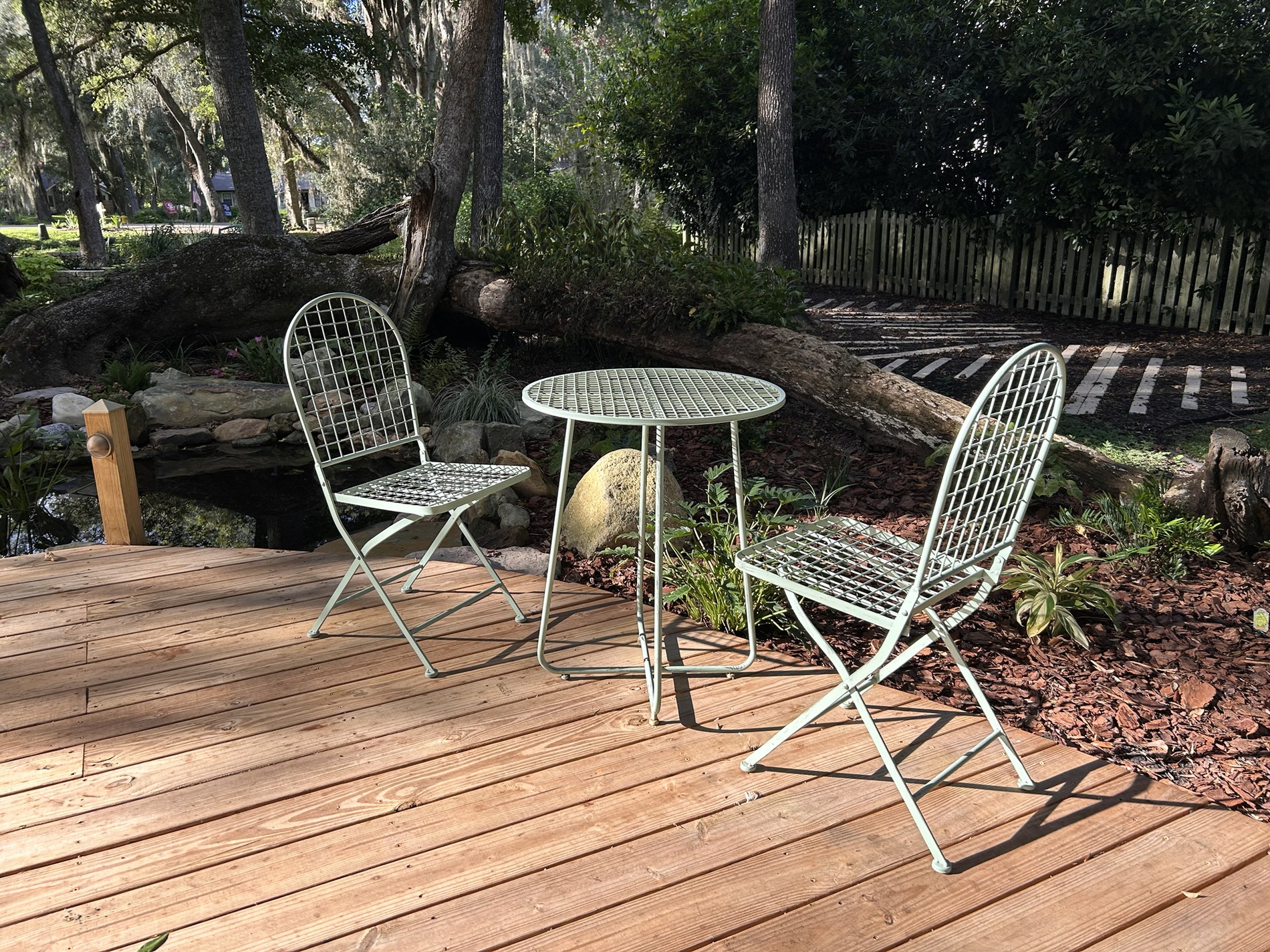 A table and two chairs beside the pond and Split Oak