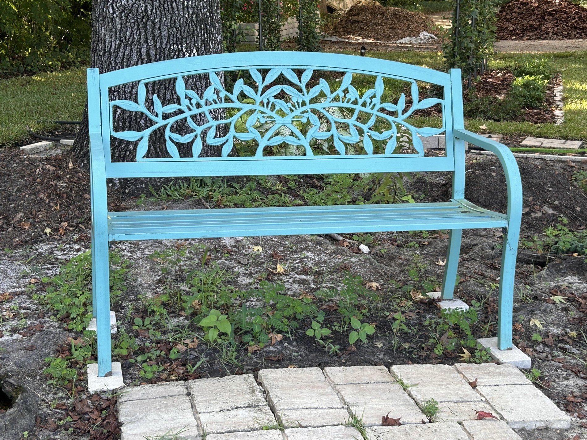The blue bench beneath a tree in the Woodland Garden